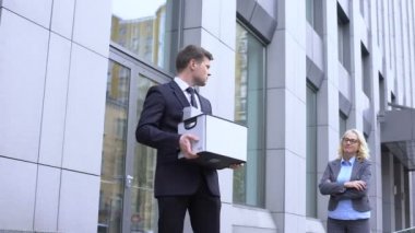 Şeyler kutusu ile üzgün erkek yöneticisi kadın patron, şirket işten böbürleniyor bakıyor