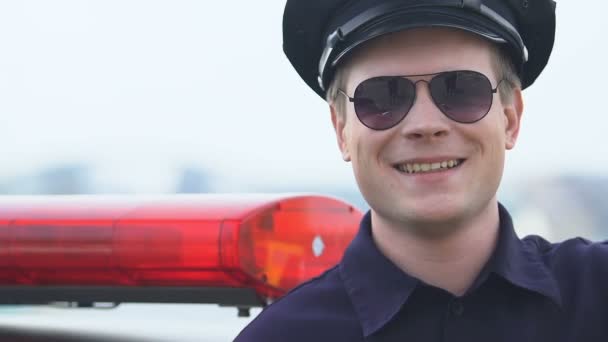 Freundlicher männlicher Polizeibeamter, der in die Kamera blickt, vertrauensvolle Polizei, Schutz — Stockvideo