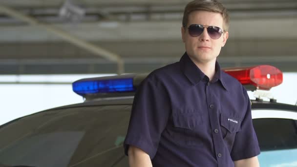 胸、法律と秩序に手を渡ってパトカーの近くに立っている警官 — ストック動画