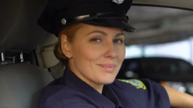 Dost polis gülümseyen ve kameraya bakan, devriye arabasında oturan, sipariş