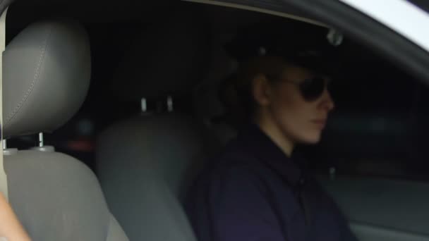 Policewoman getting in car and fastening seatbelt, female cop team driving away — Stock Video