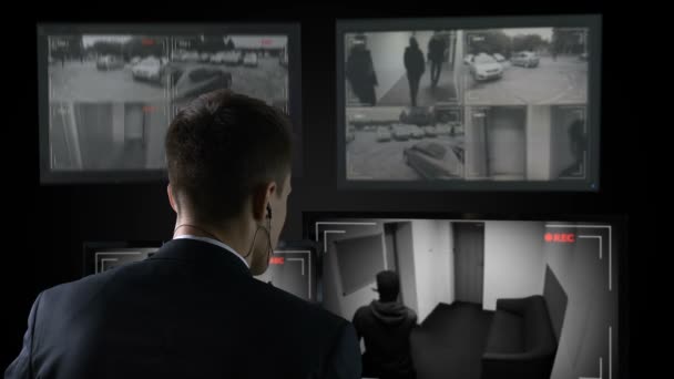 Bewaker kijken CCTV-beelden, bellen politie, dief breken in gebouw — Stockvideo