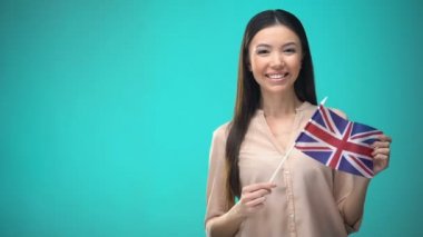 Büyük Britanya bayrağı tutan gülümseyen kadın, yabancı dil öğrenmeye hazır