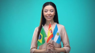 Brezilya, İspanya ve Arjantin bayrakları tutan meraklı kadın, dil öğrenme