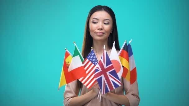 Flicka tittar på flaggor i händerna, internationella studentutbytesprogram — Stockvideo