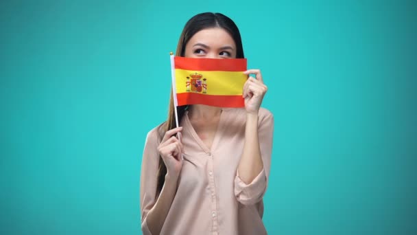 Κορίτσι που καλύπτει το πρόσωπο με ισπανική σημαία, μαθαίνοντας γλώσσα, εκπαίδευση και ταξίδια — Αρχείο Βίντεο