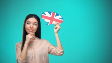 İngiliz bayrağı tabelası tutan, dil öğrenen, yurtdışında eğitim öğrenen meraklı kadın
