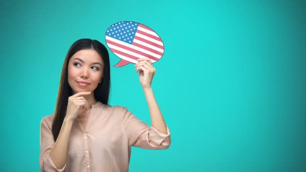 Mulher curiosa segurando EUA bandeira sinal, aprendendo idioma, educação no exterior — Vídeo de Stock