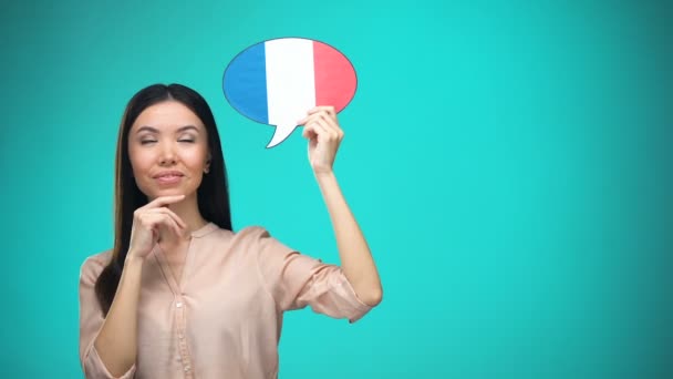 フランス国旗の看板を持つ好奇心旺盛な女性、言語を学ぶ、海外での教育 — ストック動画