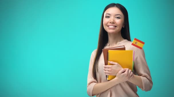 İspanyol bayraklı kitap tutan neşeli kadın, yurtdışında eğitim, dil öğrenme — Stok video