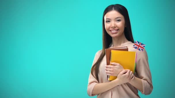 Femme joyeuse tenant le livre de drapeau britannique, éducation à l'étranger, apprentissage de la langue — Video