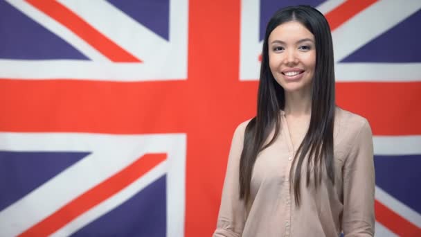 Mulher bonita mostrando polegares para cima contra o fundo da bandeira britânica, modelo — Vídeo de Stock
