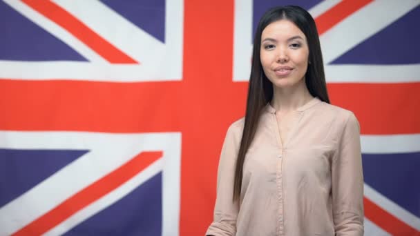 Female holding credit card against British background, international banking — Stock Video