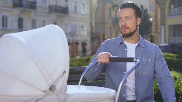 Trött sömnig man svängande barnvagn sitter på parkbänk, föräldraskap utmattning — Stockvideo