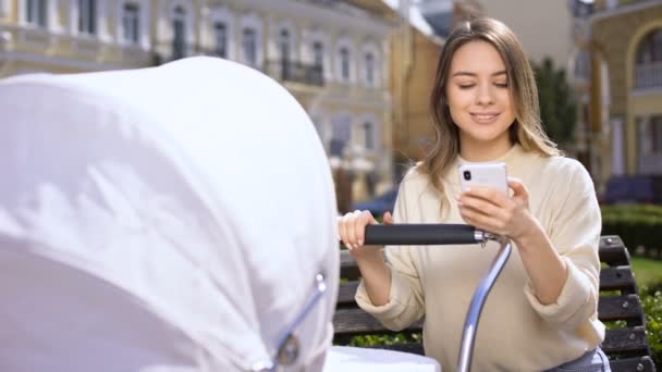 Onverantwoordelijke vrouwelijke chatten op smartphone negeren huilen baby in kinderwagen — Stockvideo