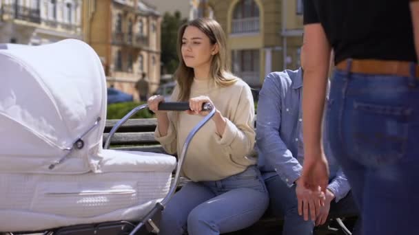 Jeune mari regardant les femmes dans la rue, femme jalouse pleurant poussette balançoire — Video