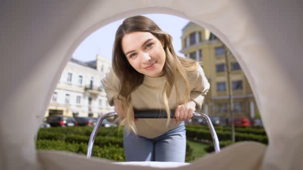 Hermosa madre sonriente admirando bebé columpio cochecito, maternidad bebé pov — Vídeos de Stock