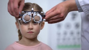 Görme sorunları, optik teşhis etmek için göz test gözlük giyen sevimli çocuk