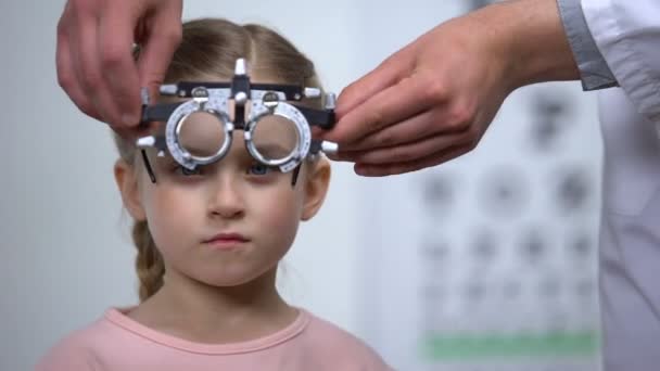 Schattig kind het dragen van oogtest brillen voor het diagnosticeren van gezichtsproblemen, optica — Stockvideo