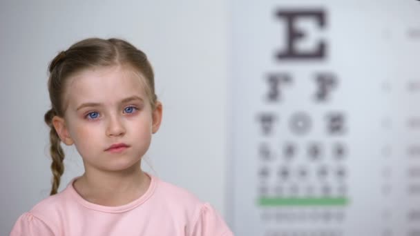 Menina rejeitando phoropter, com medo de equipamentos de exame ocular, óptica — Vídeo de Stock