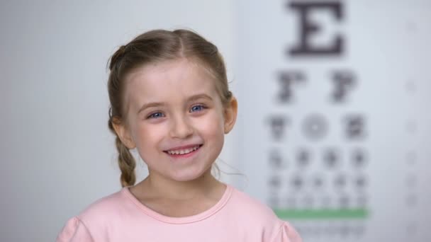 Schattig kind meisje lachen na visie test op oog grafiek, gezond zicht — Stockvideo