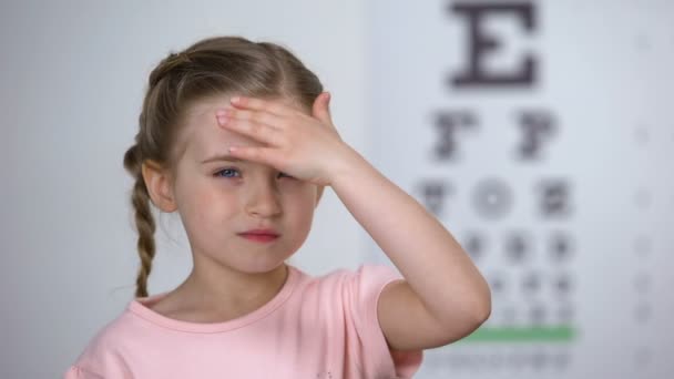 Enfant fille mignonne souffrant de maux de tête, premier symptôme de myopie, perte de la vue — Video