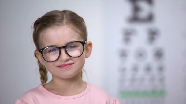 Roztomilá holčička v brýlích, které berou prášky na léčbu očí, užitečné vitamíny — Stock video