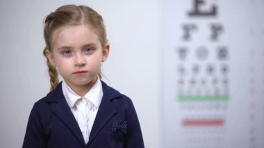 Neşeli kız öğrenci kapanış göz, oftalmoloji kliniğinde görme kontrol