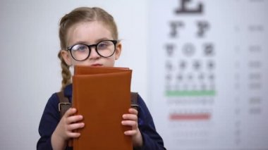 Kitap kurdu çocuk gözlük kitap sarılma, çok fazla okuduktan sonra kötü görme
