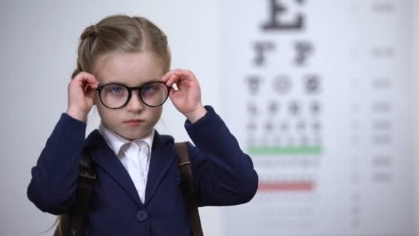 Грустная школьница снимает очки, недовольная проблемами со зрением, глазной болезнью — стоковое видео