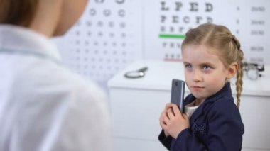 Optisyen yaramaz çocuktan cep telefonu almaya çalışıyor, video oyunları görme zarar