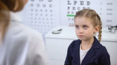 Danışman çocuğun moda gözlük, optik mağazada hizmet seçmek için yardımcı