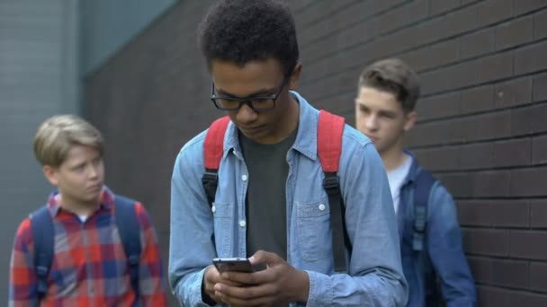 Adolescentes chicos bullying afroamericano estudiante, quitando teléfono provocando conflicto — Vídeos de Stock