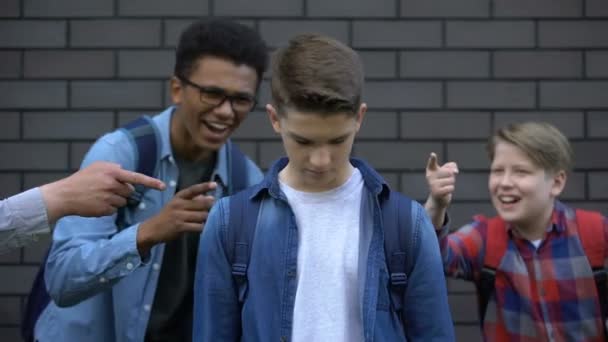 Cruel teenagers pointing at boy crying, emotionally depressed victim of bullying — Stock Video