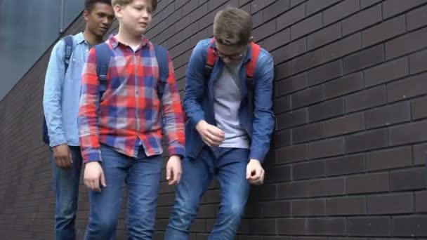 Gemiddelde studenten ponsen nerd jongen in achtertuin, school pesten, intimidatie — Stockvideo