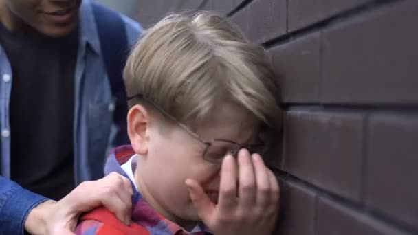 Κοντινό πλάνο από εκφοβιστικό μαθητή σε σπασμένα γυαλιά, το αγόρι που εκφοβίζει τον σπασίκλα — Αρχείο Βίντεο