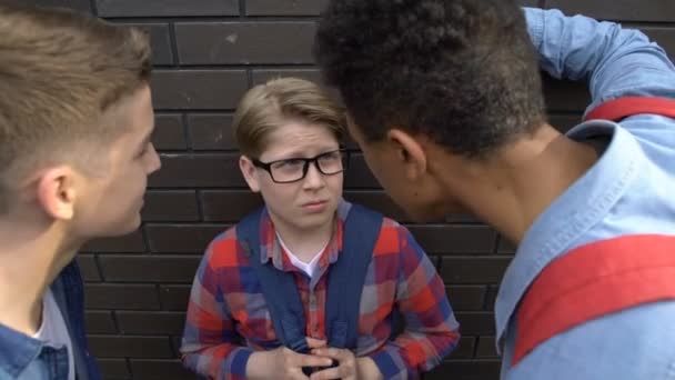 Adolescentes imprudentes bullying menino fraco, provocando sobre visão pobre, pequena estatura — Vídeo de Stock