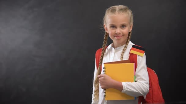 Mutlu kız öğrenci Alman bayrağı ile kitap tutan, yabancı dil öğrenmeye hazır — Stok video