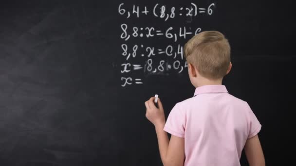 Colegial tratando de resolver el ejercicio de matemáticas cerca de pizarra, la educación primaria — Vídeo de stock