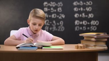 Akıllı öğrenci çözme görevi, matematik egzersizleri arkasında tahta üzerinde yazılı