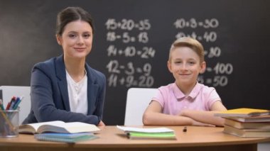 Mutlu öğretmen ve akıllı öğrenci kameraya gülümseyen, modern eğitim reformu