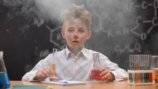 Σοκαρισμένος αστείος βρώμικος μαθητής κρατώντας χημικό σωλήνα και φιάλη, καπνός γύρω του — Αρχείο Βίντεο