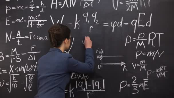 Female tutor writing formula on chalkboard, mathematics lecture, exact sciences — Stock Video