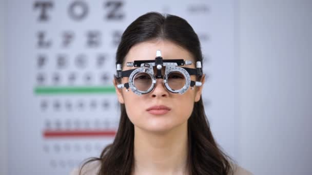 Doctor choosing lenses for patient in optical trial frame, lady shaking head — Stock Video