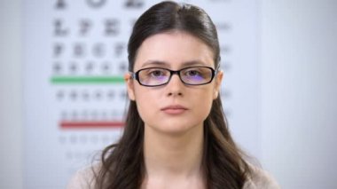 Gülümseyen bayan gözlük lerini çıkarıp kontakt lens ile kılıf gösterme, iyileştirme