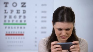 Telefonda oyun oynarken görme engelli kadın, görme kaybı riski, bağımlılık