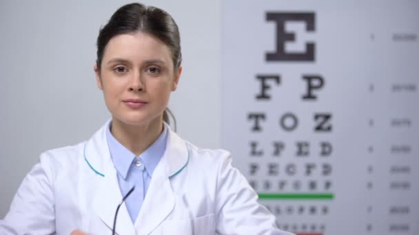 Ophtalmologiste féminine souriante recommandant des lunettes, correction de la vue — Video