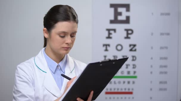 Sonrientes resultados de la prueba de escritura oculista femenina y sonrientes, buenos resultados de tratamiento — Vídeos de Stock