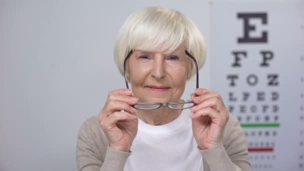 Glückliche Rentnerin setzt neue Brille auf und hofft auf Besserung — Stockvideo