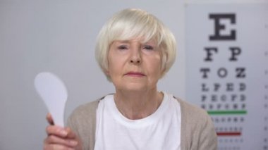 Yaşlı bayan kapanış göz ve görme testi sonucu ile üzgün başını sallayarak, kötü görme